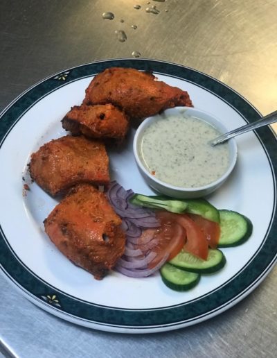 Tandoori Chicken with salad and dressing on plate